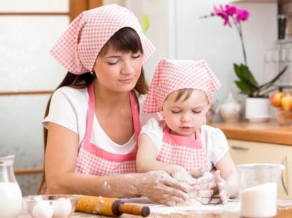 Mother and daughter making cookie dough together at kitchen