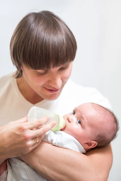 Father feeding his baby infant from bottle