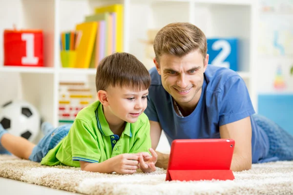 Man and son kid playing with tablet computer