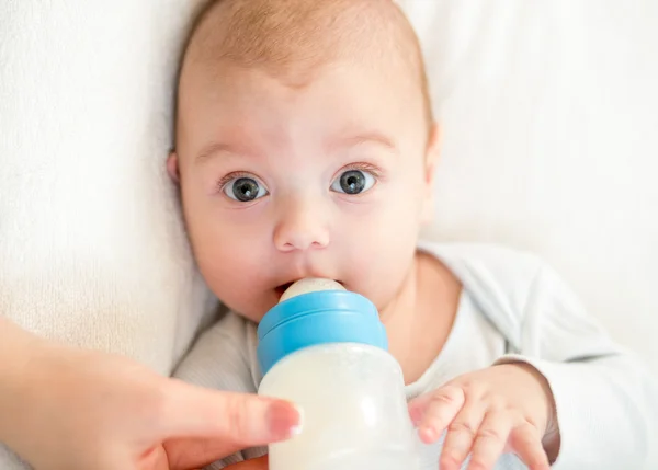 Baby boy eating from milk bottle