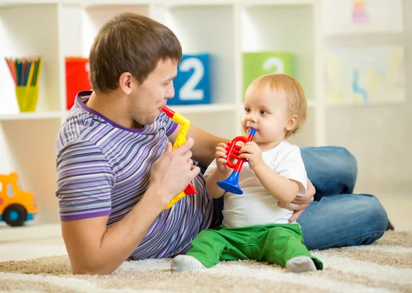 Happy family dad and son play musical toys