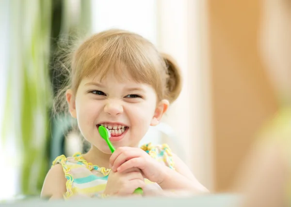 Funny child girl brushing teeth