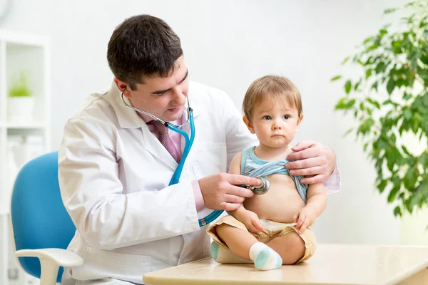 Doctor man examining heartbeat of kid boy with stethoscope