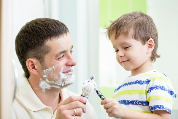 Dad and son shaving in bathroom