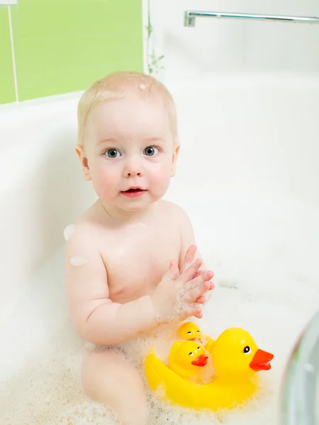 Baby clapping hands and smiling while taking a bath