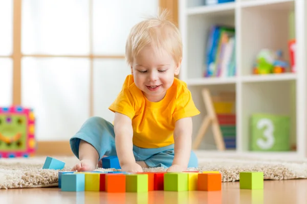 Kid boy playing wooden toys