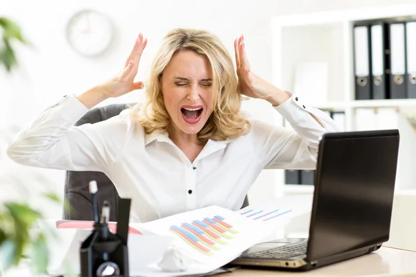 Stressed business woman screaming loudly working in office