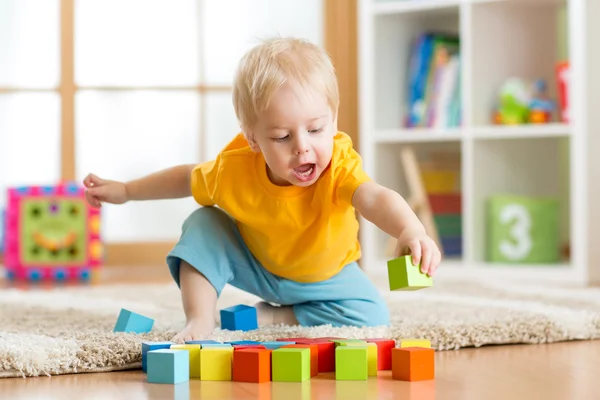 Kid boy playing wooden toys