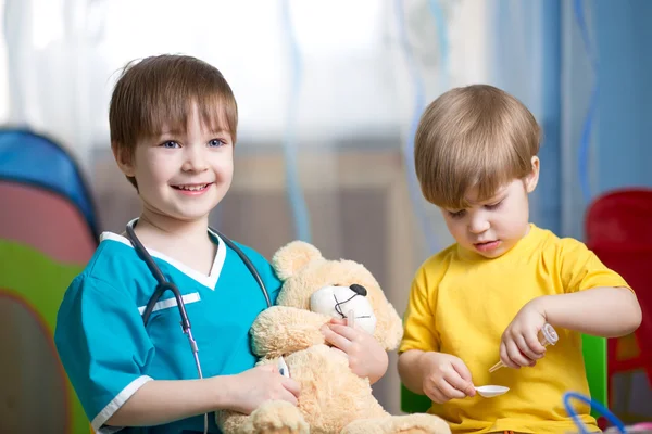 Little kids play doctor with plush toy