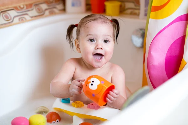 Funny baby smiling while taking a bath