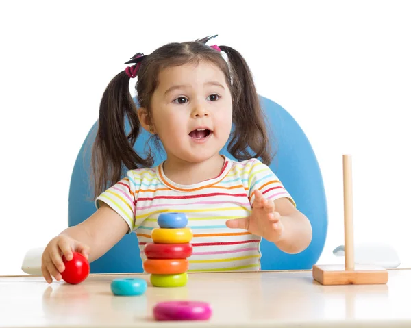 Child playing with color pyramid toy