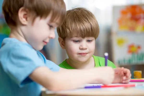 Kids boys painting in nursery at home