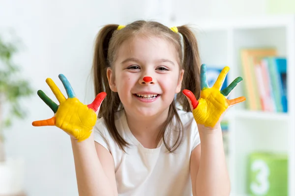 Cute cheerful child with painted hands and face