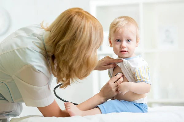 Pediatrician examining heartbeat of kid with stethoscope