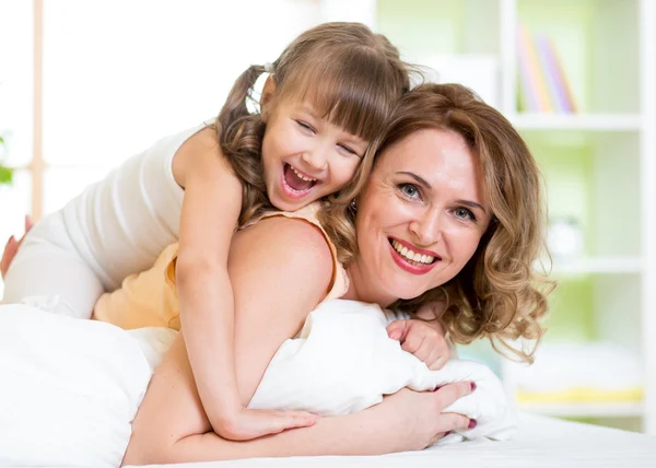 Mother and child having fun in bed