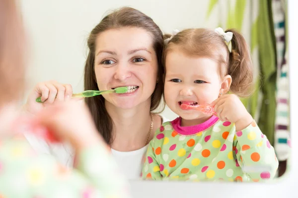 Mother teaching child teeth brushing