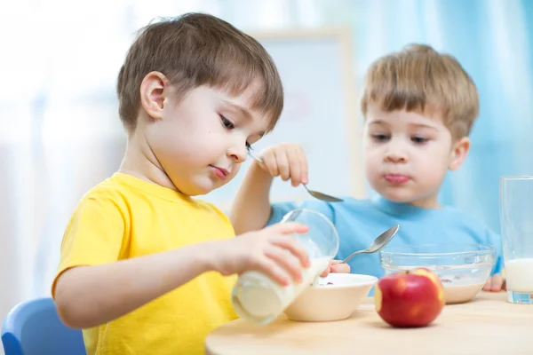 Children eating healthy food in kindergarten or nursery