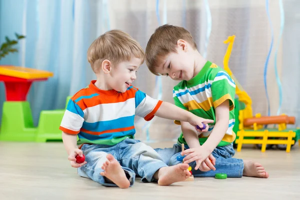 Children brothers playing together in nursery  or day care center