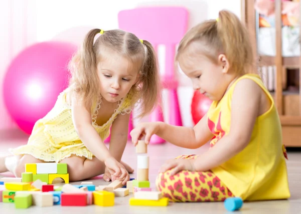 Children playing wooden toys at home