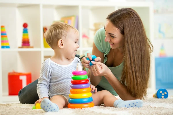 Cute mother and child boy play together indoor at home