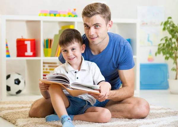 Cute smiling kid reading book in children room