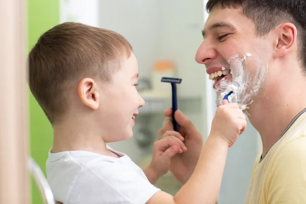 Daddy and his child shaving and having fun in bathroom