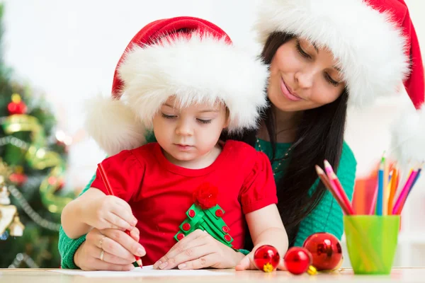 Child girl and mother writing letter to Santa