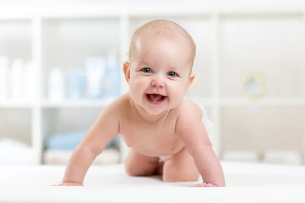 Happy baby child crawling on bed and smiling