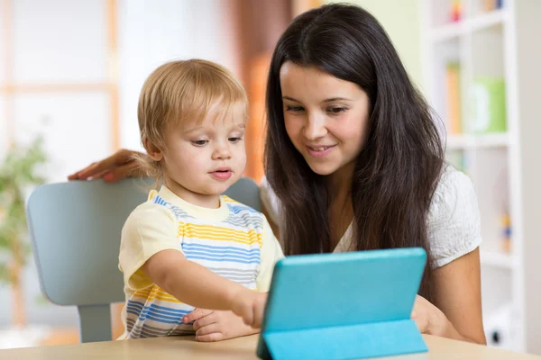Mother reads a fairy tale to her son from a digital tablet pc