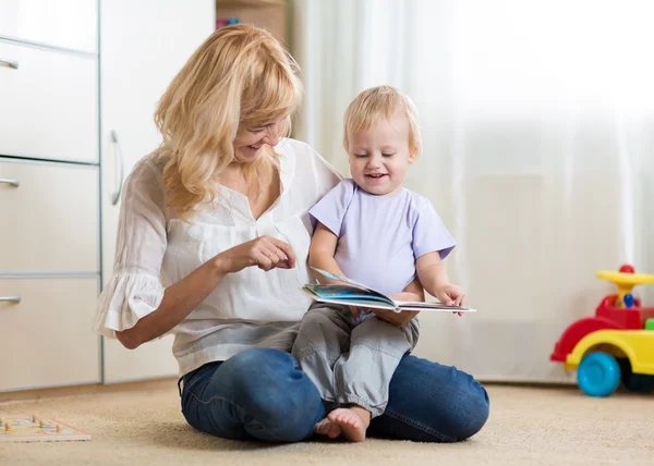 Mom and kid boy read a book at home