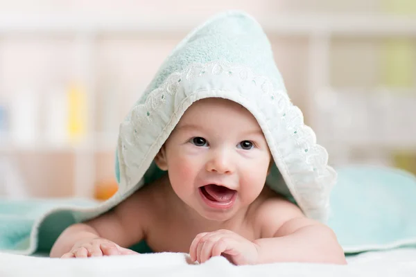 Funny baby kid under a hooded towel after bath