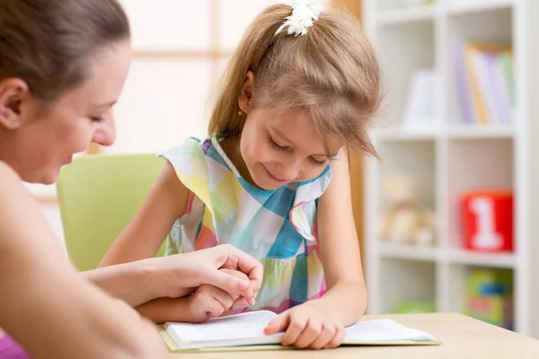 Preschooler Child Reading with Mother In Nursery at Home