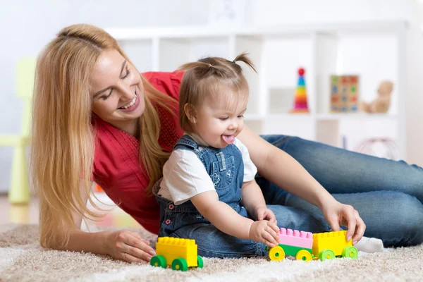 Mother and child girl playing together indoor