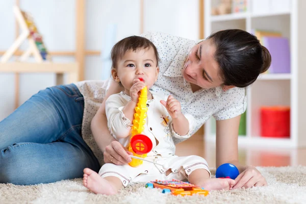 Mom and baby playing musical toys at home