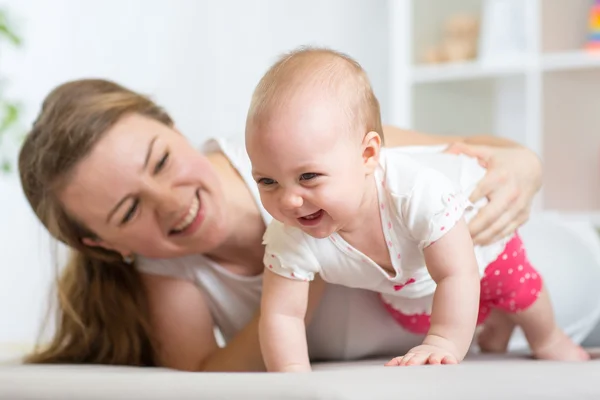 Happy crawling baby girl with mother