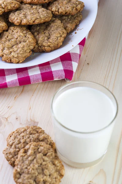 Glass of milk and crispy oatmeal cookies