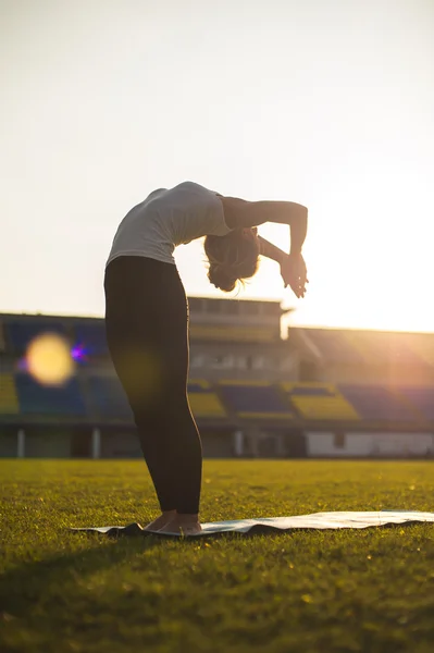 Yoga woman in park at sunset