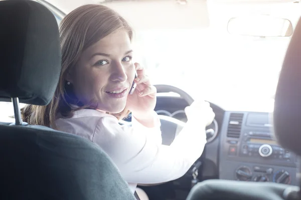 Happy Attractive woman talking on the phone in car
