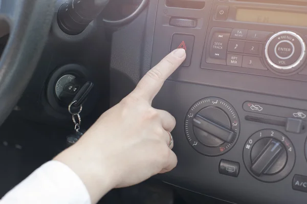 Closeup of female hands pushing emergency button in car