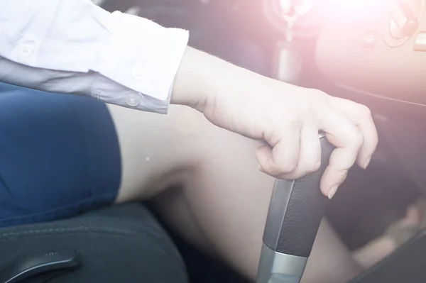 Closeup of female hand holding car transmission handle