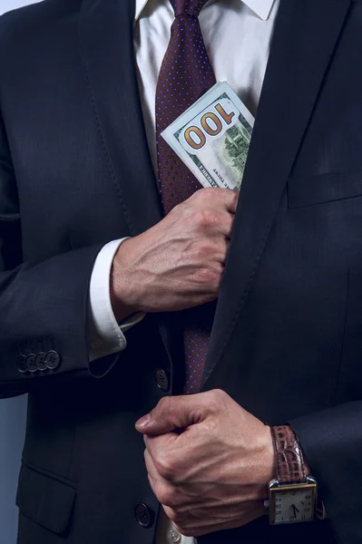 Man removes US dollars in his suit pocket