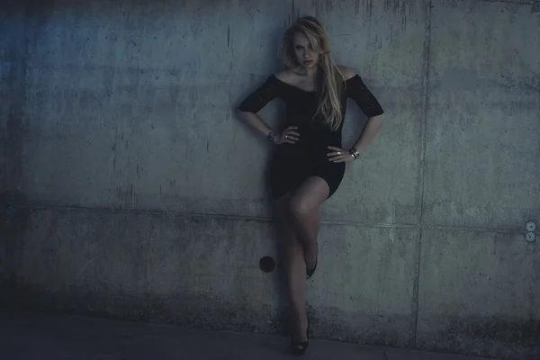 Woman dressed in black dress posing