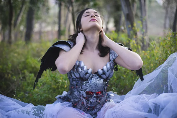 Brunette with silver armor lying in a forest, romantic style loo