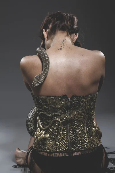 Woman in iron corset with snake