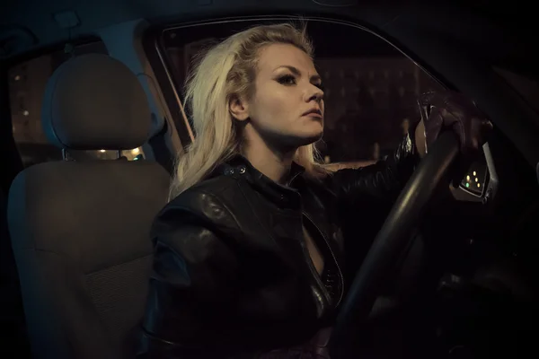 Blonde in car driving at night