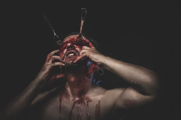 Naked man with blindfold and forks