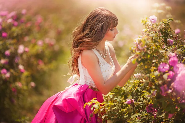 Beautiful girl dancing in a field of roses