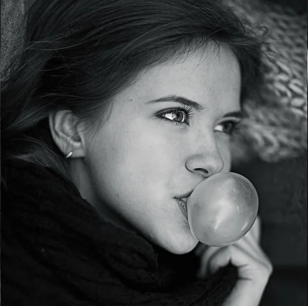 Young girl blowing gum bubble