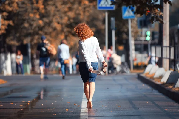 Barefoot girl walking on the street