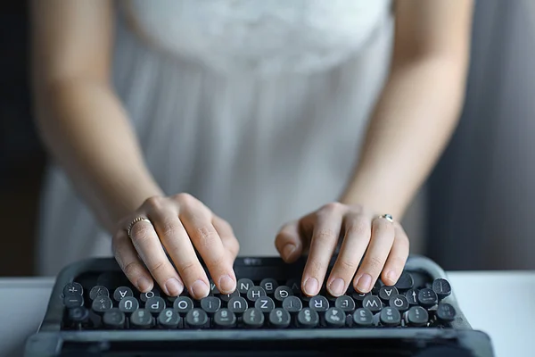 Hands typing on old typing machine